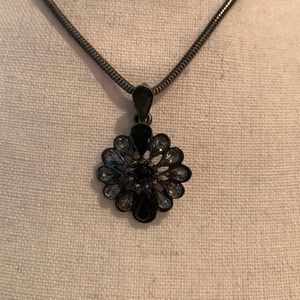 Adjustable rhinestone pendant on black snake chain.
